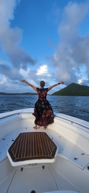 Souyenne on a boat, arms open to the sea